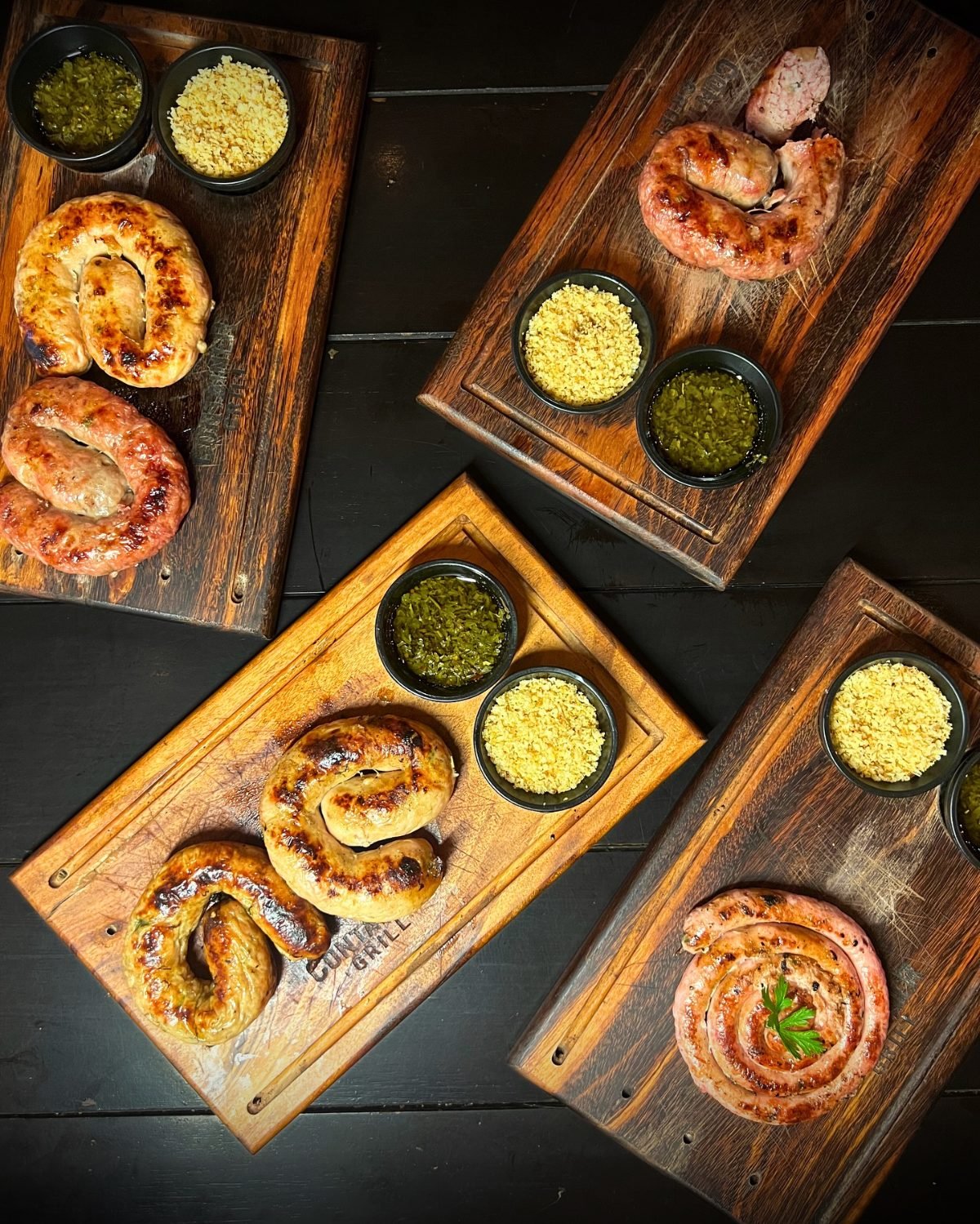 Quatro tábuas Container Grill com linguiça cuiabana artesanal, farofa e molho verde